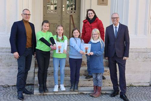 Oberbürgermeister Peter Kleine, Frida, Rebekka, Olivia, Luna, Kinder- und Jugendbeauftragte Sina Solaß und Bürgermeister Ralf Kirsten zeigen den Rathausführer