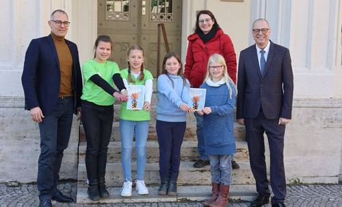 Oberbürgermeister Peter Kleine, Frida, Rebekka, Olivia, Luna, Kinder- und Jugendbeauftragte Sina Solaß und Bürgermeister Ralf Kirsten zeigen den Rathausführer