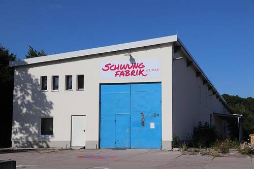 Das Bild zeigt den Haupteingang der Schwungfabrik ein großes , blaues Tor ist zu sehen.