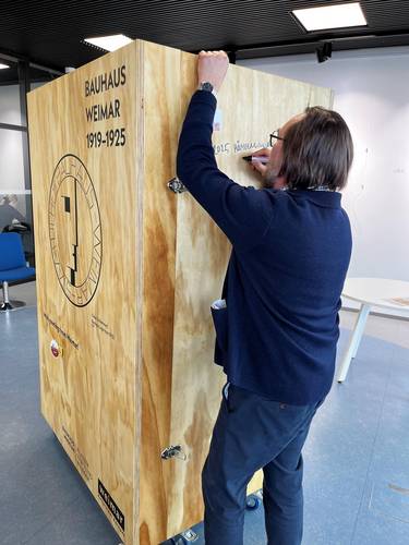 Der Kulturbeauftragte der Stadt Hämeenlinna, Janne Nieminen, signiert den Ausstellungskoffer