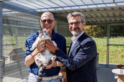 Bürgermeister Ralf Kirsten, Staatssekretär Udo Götze halten grau weiße Katze auf dem Arm