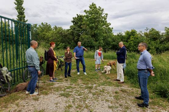 Menschengruppe im Grünen, die Hundewiese wird eröffnet