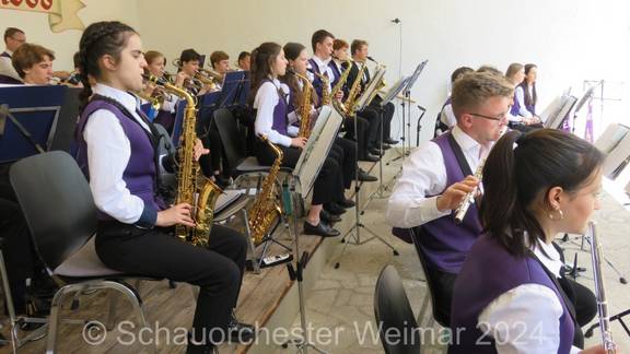 Auf dem Bild sind musizierende Kinder und Jugendliche mit Instrumenten zu sehen.