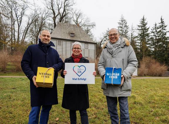 Weimars Oberbürgermeister Peter Kleine, Ulrike Köppel (Geschäftsführerin weimar GmbH) und Ralf Kirsten (Bürgermeister und Kulturdezernent von Weimar) mit den ´99er „Kulturstadtpäckchen“ und dem Logo Chemnitzer Kulturstadtlogo vor dem Goethe-Gartenhaus