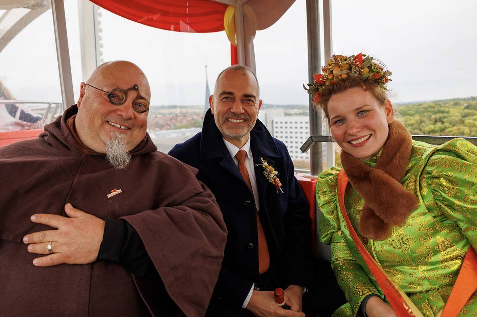 Auch die taditionelle Riesenradfahrt gehört zum Programm. Zwiebelmönch Theo, Oberbürgermeister Peter Kleine und Roswitha I. sehen sich das Marktgebiet von oben an. ©Stadt Weimar Drei Personen in einer Riesenradgondel
