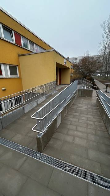 Die beiden maroden Außentreppen wurden von Grund auf erneuert, die Kelleraußenwände gegen Feuchtigkeit abgedichtet und an einem Eingang eine regelkonforme Rampe zur barrierefreien Erschließung ergänzt.