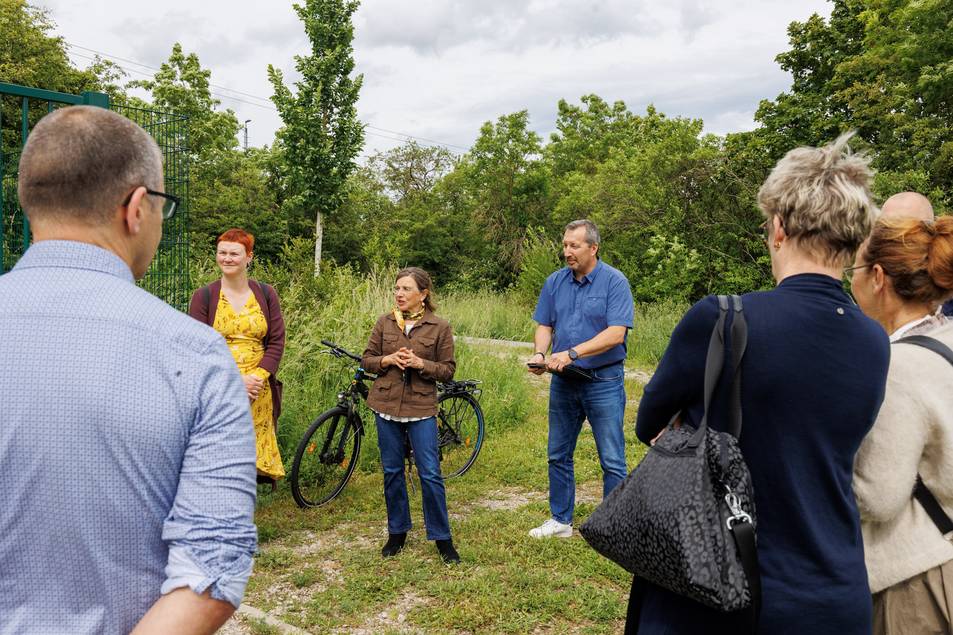Menschengruppe steht im Kreis, zwei Personen im Fokus