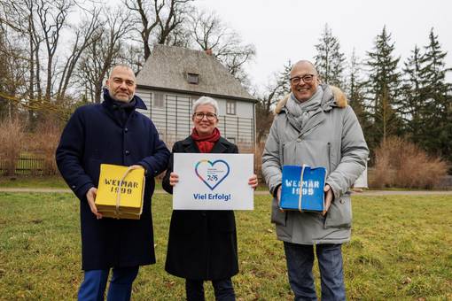 Weimars Oberbürgermeister Peter Kleine, Ulrike Köppel (Geschäftsführerin weimar GmbH) und Ralf Kirsten (Bürgermeister und Kulturdezernent von Weimar) mit den ´99er „Kulturstadtpäckchen“ und dem Logo Chemnitzer Kulturstadtlogo vor dem Goethe-Gartenhaus