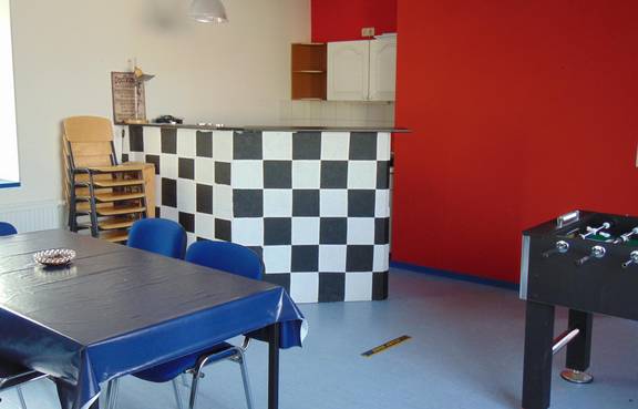 Auf dem Bild ist die Innenansicht des Jugendzimmers Tröbsdorf zu sehen, man sieht den Thresen und eine rote Wand.