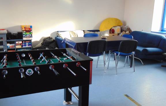 Auf dem Bild ist das Jugendzimmer Tröbsdorf von innen zu sehen, man sieht den Kicker und das Sofa.