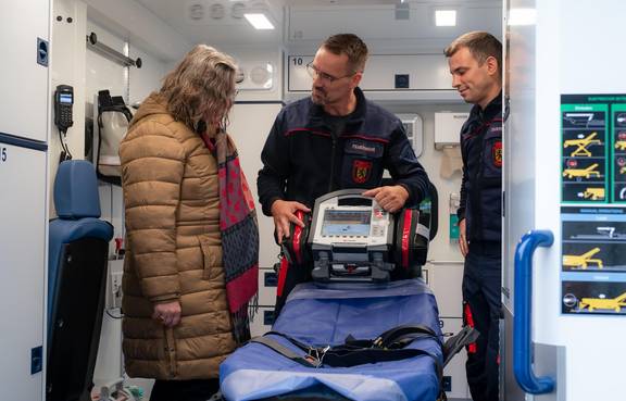 Geräumiger Behandlungsraum mit komfortabler Rettungstrage; durch die Einsatzkräfte werden die Möglichkeiten des RTW gezeigt