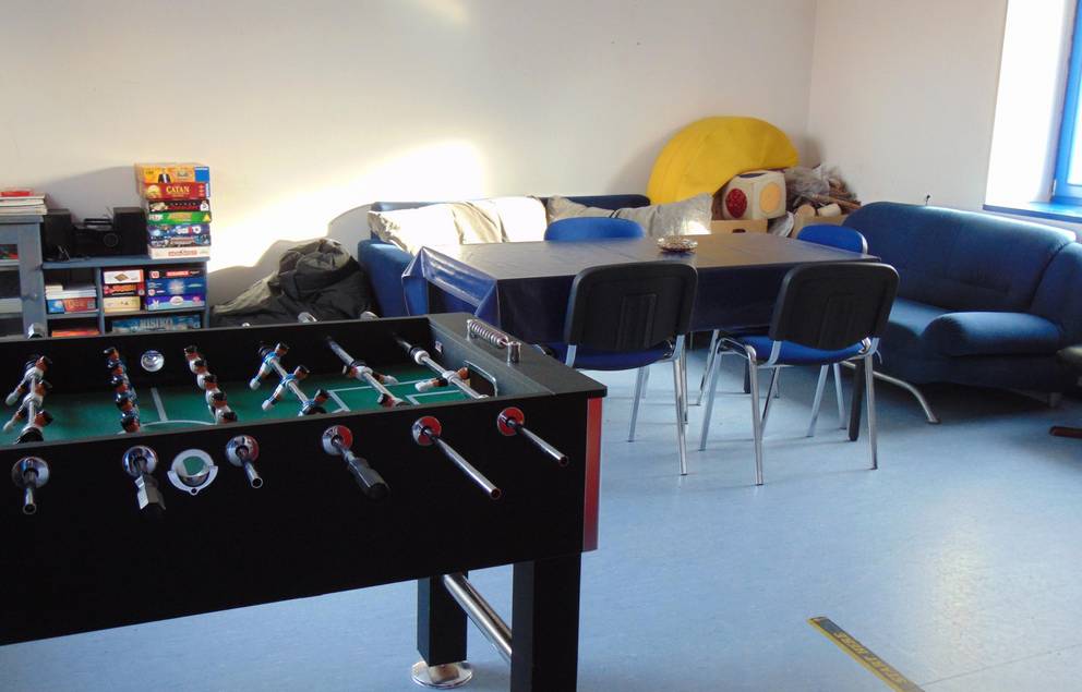 Auf dem Bild ist das Jugendzimmer Tröbsdorf von innen zu sehen, man sieht den Kicker und das Sofa.