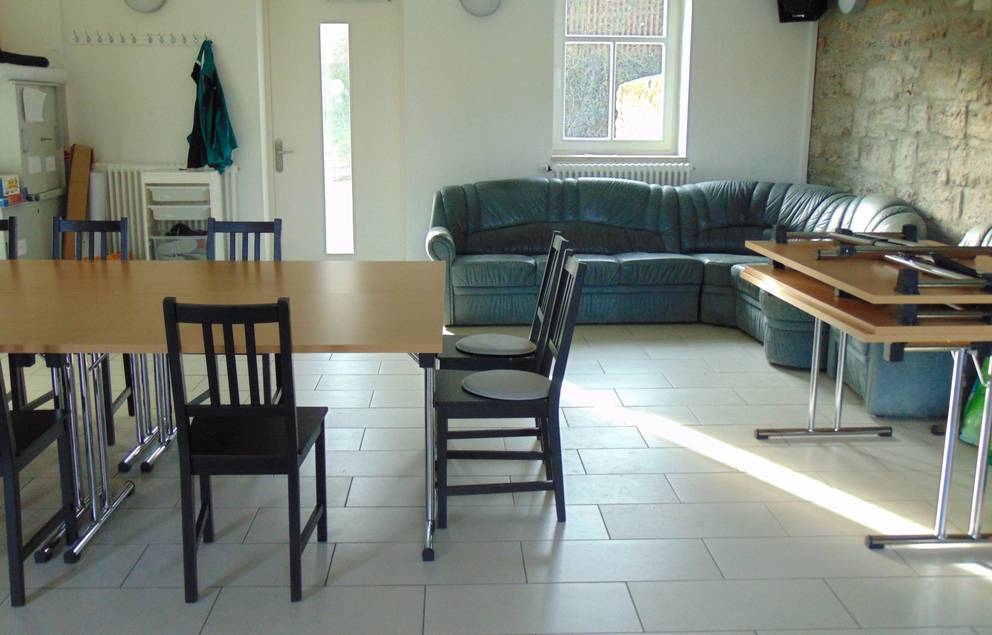 Auf dem Bild ist die Innenansicht des Jugendzimmers Süßenborn zu sehen, man kann ein Sofa und Stühle sehen.