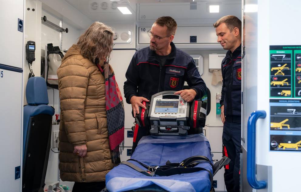 Geräumiger Behandlungsraum mit komfortabler Rettungstrage; durch die Einsatzkräfte werden die Möglichkeiten des RTW gezeigt